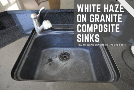 A white haze on a black composite granite sink and a black pearl granite countertop.