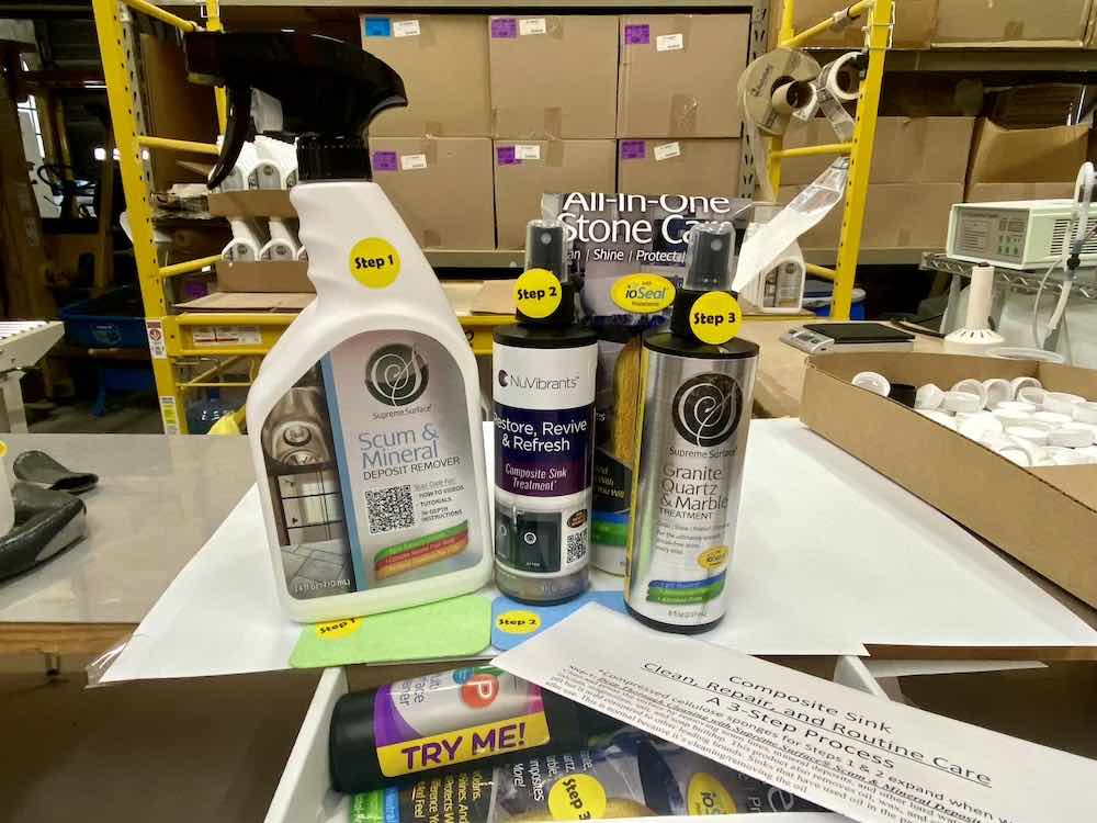 Official image of Supreme Surface Granite Sink Cleaners Repair and Routine Protective Care Kit. From Left to right: Supreme Surface® Scum & Mineral Deposit Remover, Restore Revive Refresh Composite Sink Treatment, Granite Quartz & Marble Treatment, Two Supreme Surface Sponges, Written Instructions "Composite Sink Clean, Repair and Routine Care 3-Step Process", and a Try Me Sample of CTP Multi-Surface Cleaner (streak-free, pH-neutral, alcohol-free, ammonia-free, fragerance-free)