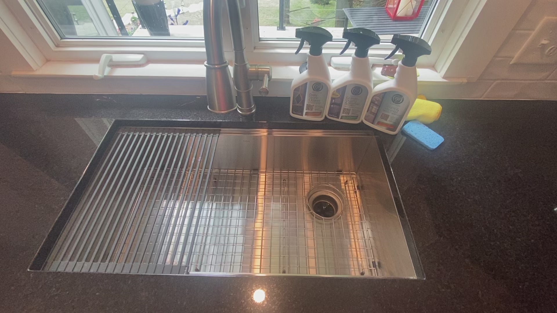 Cleaning black granite countertops and Kraus stainless steel sink with Supreme Surface Daily Stone Cleaner, Granite Quartz & Marble Treatment, and Scum  Mineral Deposit Remover. 